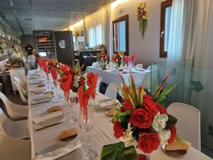 a long table with red and white flowers on it at Casa Marisa in San Asensio