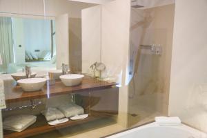 a bathroom with two sinks and a shower at Real Abadia, Congress & Spa Hotel in Alcobaça
