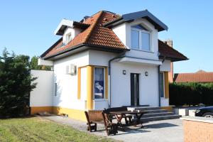 a small white house with a table in front of it at Hotel Rózsa Csárda Bungalow & Caravan Park in Hegyeshalom