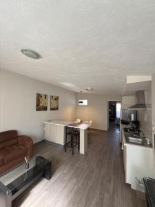 Una cocina y una sala de estar con un sofá y una mesa. en Bellísimo departamento, lo vas a disfrutar!, en Monterrey