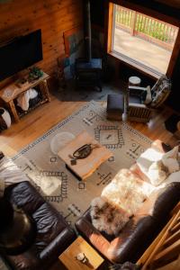Una sala de estar con un sofá de cuero y una alfombra. en COZY Cabin with Hot Tub - Near all in Hocking Hills, en Logan