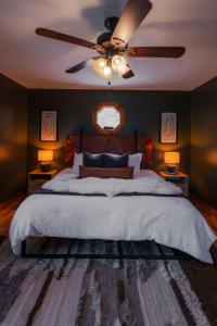 Un dormitorio con una cama grande con ventilador de techo. en COZY Cabin with Hot Tub - Near all in Hocking Hills, en Logan