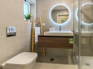 a bathroom with a sink and a toilet and a mirror at Apartamento Vista Mar -Marzaré in Nazaré +43 photos