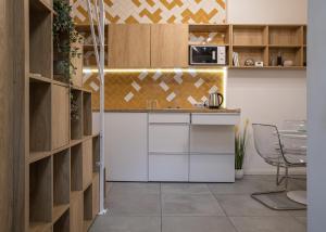 a kitchen with white cabinets and a table and chairs at Cozy House Apartment Cluj Central in Cluj-Napoca