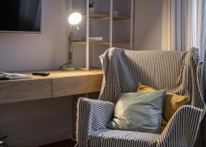 a chair with a pillow sitting next to a desk at Cozy House Apartment Cluj Central in Cluj-Napoca