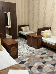 une chambre avec trois lits et une table dedans dans l'établissement Narek+, à Erevan 108 autres photos