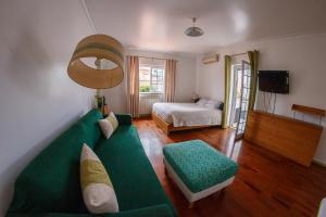 a living room with a green couch and a bed at Casa do Marmeleiro Guest House in Alcabideche +70 photos