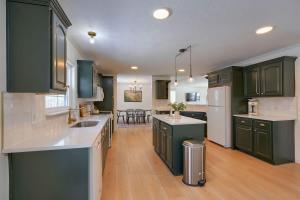 a kitchen with green cabinets and a dining room at Buckingham Woods I Hocking Hills in Logan