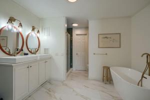 a bathroom with two mirrors and a tub and a sink at Buckingham Woods I Hocking Hills in Logan
