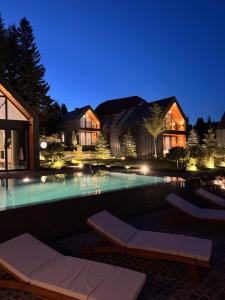 a house with a swimming pool at night at Garden Hill Mitrovac na Tari in Mitrovac