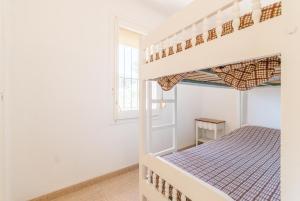 a bedroom with bunk beds and a window at Apartaments Fincasol in L'Estartit