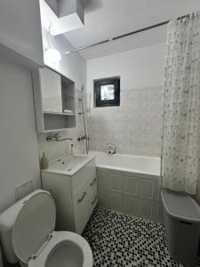 a bathroom with a toilet and a tub and a sink at Apartament Poiana Câmpina in Poiana Campina