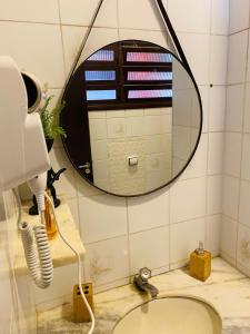 ein Badezimmer mit Spiegel und Waschbecken in der Unterkunft Kitnet completa 150 mts da Praia in Ubatuba