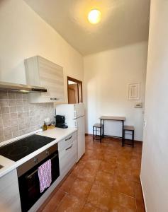 a kitchen with white cabinets and a stove top oven at Valfò Lodge The City in La Spezia +7 photos