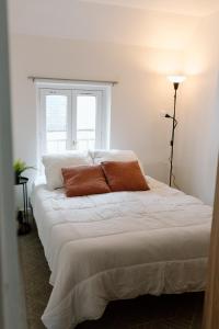 a large white bed in a room with a window at Le Tiny Chalet in Étampes
