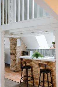 a kitchen with two stools and a counter with a microwave at Le Tiny Chalet in Étampes