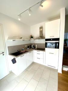 a white kitchen with white cabinets and appliances at Luxuriöses Penthouse mit Parkplatz zentral in Eltville in Eltville