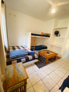 ein Zimmer mit zwei Etagenbetten und einem Tisch in der Unterkunft Kitnet completa 150 mts da Praia in Ubatuba