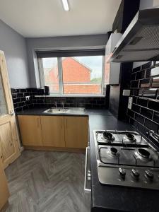 a kitchen with a stove and a sink and a window at Spacious Home Near City Centre in Kenton +11 photos