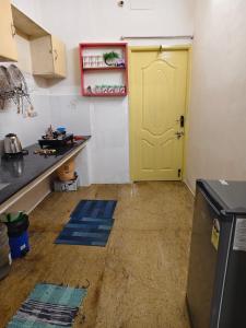 eine Küche mit einer gelben Tür und blauen Matten auf dem Boden in der Unterkunft Garden Home stay Service apartment in Jāmb
