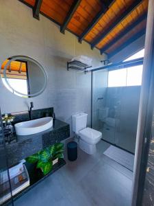 a bathroom with a toilet and a sink and a shower at Chalé Heinz in Rancho Queimado +25 photos