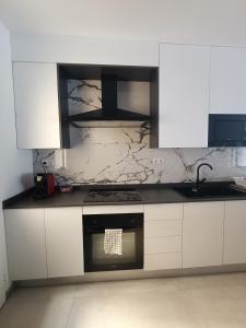 a kitchen with white cabinets and a marble counter top at Casa Aguadulce Puerto in Aguadulce