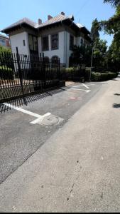 a house with a fence in front of a street at G&A Luxe Apartment Central in Târgu Jiu