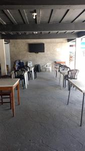 a group of tables and chairs in a room at Recanto da Alegria suítes in Cabo Frio