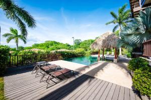 a deck with chairs and a swimming pool at Rooftop Pool & Ocean Views, Sunset BBQ in Ocotal