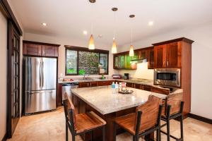 a kitchen with a large island with wooden cabinets at Rooftop Pool & Ocean Views, Sunset BBQ in Ocotal