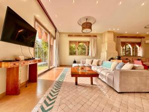 een woonkamer met een bank en een tv bij Chanel in Marrakesh