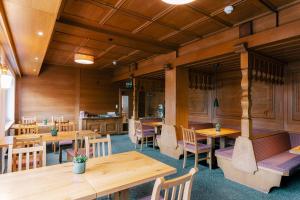 a restaurant with wooden walls and tables and chairs at Heiterwanger Hof Appartments in Heiterwang