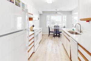 a kitchen with white appliances and a table with chairs at Yellowfin in Buxton