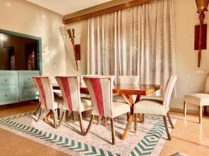 een eetkamer met een houten tafel en stoelen bij Chanel in Marrakesh