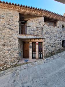 a stone building with a balcony on a street at La Casa del Arco in Añón
