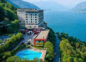a large building on a hill next to the water at Monolocale Riva Lake in Valbrona