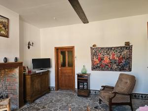a living room with a tapestry hanging on the wall at Les Roses du Souvenir in Mailly-Maillet