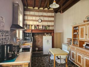 a kitchen with a table and a counter top at Les Roses du Souvenir in Mailly-Maillet