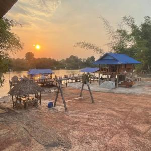a resort with tables and with the sunset at Luna bungalow chi phat in Chi Phat