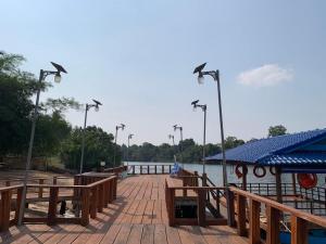 a dock with benches and lights next to a body of water at Luna bungalow chi phat in Chi Phat