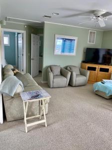 Una sala de estar con un sofá y un televisor. en Welcome To Your Dream Vacation Rental In The Heart Of Peahala Park, Just Steps Away From The Pristine Beaches Of The Ocean Block, en Peahala Park