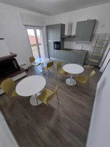 a room with tables and chairs and a kitchen at Astra in Francavilla al Mare