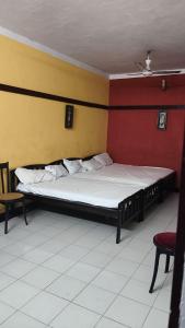 瓦尔卡拉VALLABHAN INTERNATIONAL resort的红色和黄色墙壁间的一张床位
