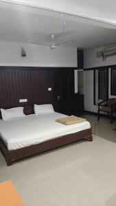 瓦尔卡拉VALLABHAN INTERNATIONAL resort的卧室里有一张铺着白色床单的大床