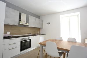 Casa BEA 1 في كاستوني ديلا بريسولانا: مطبخ مع طاولة خشبية وكراسي بيضاء +6 صور