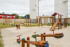 a playground with wooden play equipment in a park at Apartamento em Guaratiba a 20 min da Praia Recreio in Rio de Janeiro