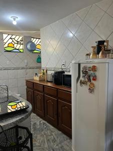 a kitchen with a refrigerator with magnets on it at Quarto na Av Beira mar em apto familiar in Fortaleza