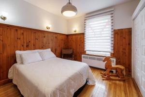 une chambre avec un lit blanc et une fenêtre dans l'établissement Downtown Heritage House and Free Parking, à Joliette