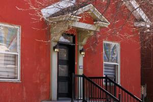 une maison rouge avec une porte et des fenêtres noires dans l'établissement Downtown Heritage House and Free Parking, à Joliette