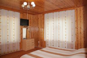 a bedroom with a bed and a tv and curtains at Qala Masalli Resort in Masallı